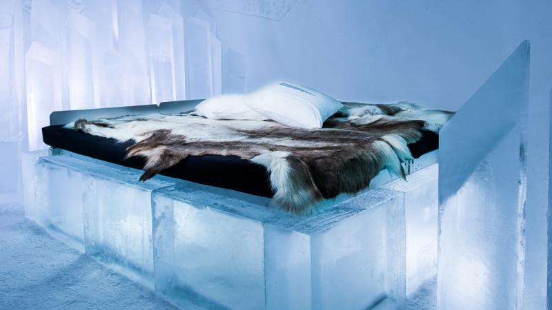 An ice bed with a reindeer fur on it at Icehotel