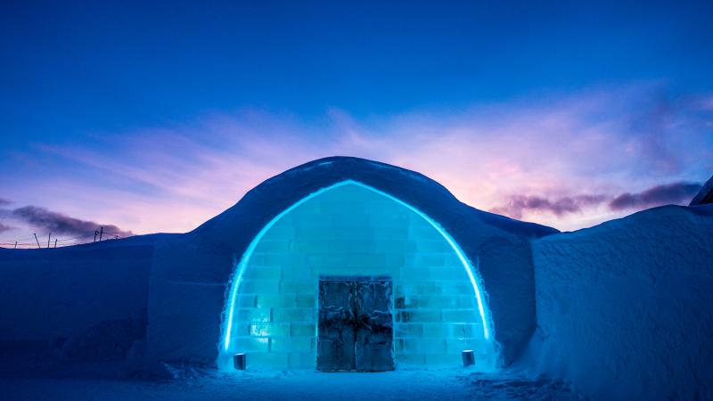 The iconic entrance to Icehotel 29 in blue and purple light